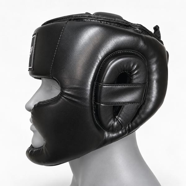 Schwarzer gepolsterter Sportco Kopfschutz für Boxtraining in Seitenansicht auf einem grauen Kopfmodell, mit verstärktem Wangen- und Kinnschutz sowie gepolstertem Ohrenschutz.