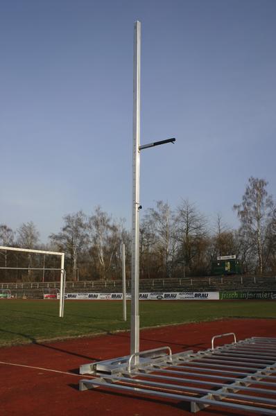 Hochsprungständer auf einer Leichtathletikbahn bei klarem Himmel.