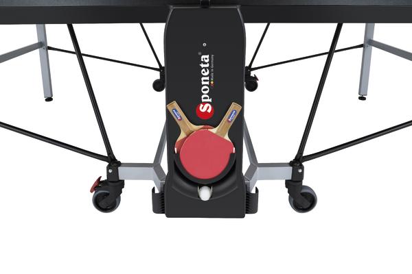 Sponeta Tischtennisplatte mit zwei Schlägern und Ballhalterung unter dem Tisch.