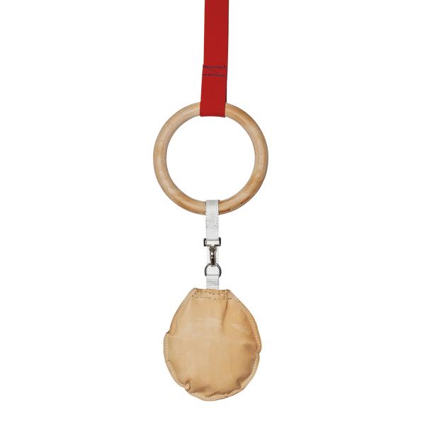 Holzturnring mit rotem Band und beigefarbenem Griffpolster, freigestellt auf weißem Hintergrund.