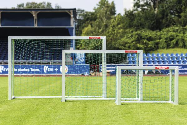 Drei verschiedene Fußballtore in verschiedenen Größen auf einem grünen Spielfeld im Stadion.
