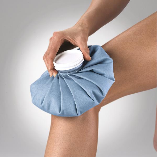 Eisbeutel wird auf schmerzendes Knie zur Kühlung und Schmerzlinderung gelegt.