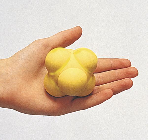 Hand hält gelben Massageball mit mehreren Kugeln zur Muskelentspannung.