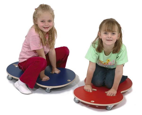 Zwei Mädchen sitzen auf bunten Rollbrettern und spielen auf weißem Hintergrund.
