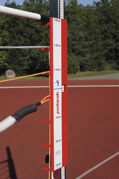 Hochsprunglattenhalter mit Höhenmarkierungen auf rotem Sportplatz bei Sonnenschein.
