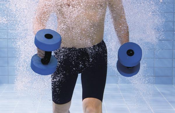 Mann trainiert mit blauen Hanteln unter Wasser im Schwimmbecken.