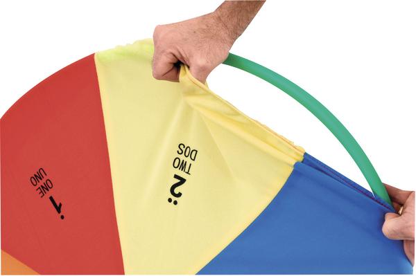 Bunte Wurfscheibe mit Zahlen und Händen, die sie spannen, Nahaufnahme.