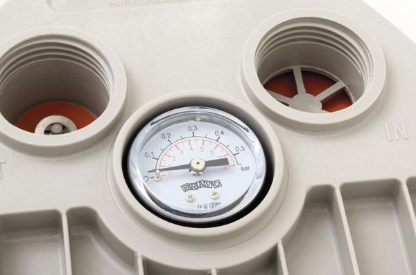 Manometer zeigt Druckmessung an einem technischen Gerät mit Kunststoffgehäuse.