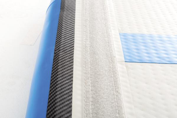 Nahaufnahme einer blauen und weißen aufblasbaren Stand-Up-Paddle-Board-Oberfläche mit Klettverschluss.