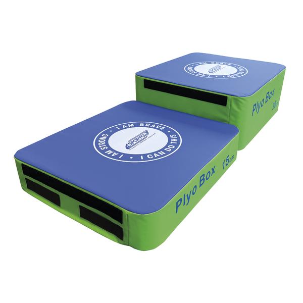 Zwei weiche Plyo-Boxen in unterschiedlichen Höhen (15 cm und 30 cm) mit blauer Oberseite und grünem Korpus, ausgestattet mit seitlichen Griff- und Klettflächen für sicheres Stapeln.