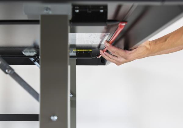 Hand montiert mit Schraubendreher ein Metallgestell, Nahaufnahme von unten.