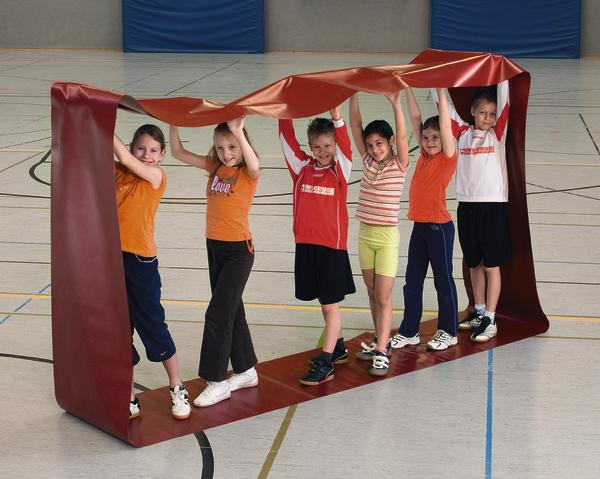 Sechs Kinder spielen gemeinsam mit einem roten Bewegungsband in der Sporthalle.
