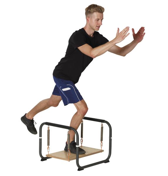 Mann trainiert Gleichgewicht auf wackelnder Plattform mit Federn, Sportbekleidung.