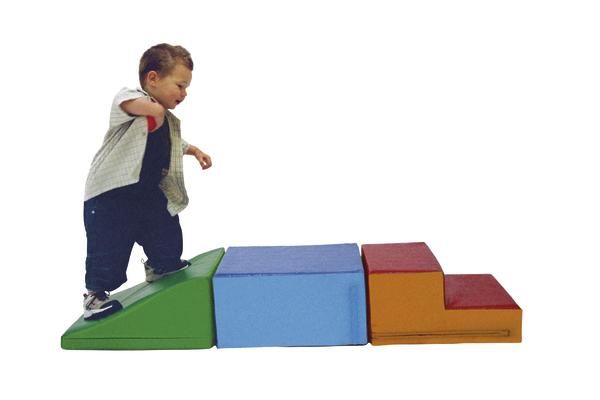 Kleinkind klettert auf bunten Schaumstoffspielplatz mit Rampe und Treppenstufen.