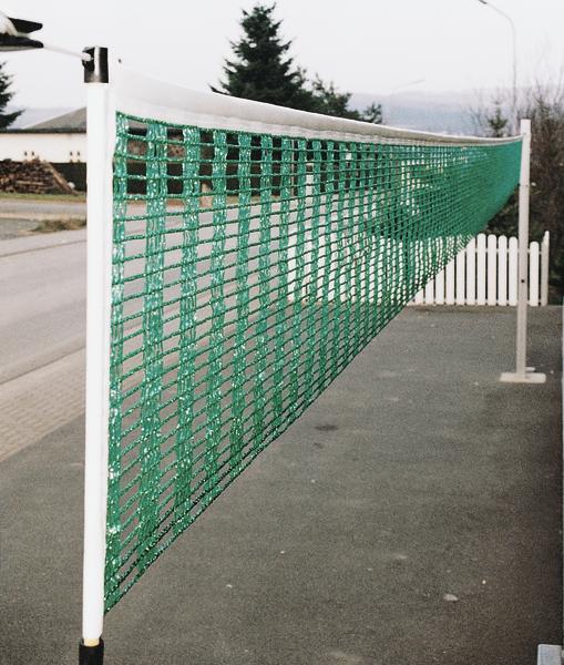 Grünes Volleyballnetz auf weißem Rahmen im Außenbereich neben Straße und Zaun.