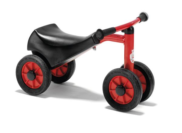 Rotes Laufrad mit schwarzem Sitz und vier Reifen für Kleinkinder, isoliert auf weißem Hintergrund.