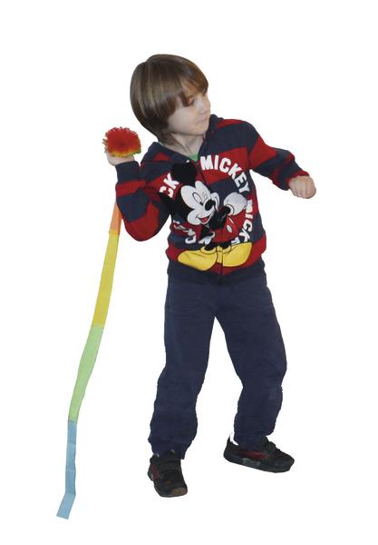 Kind mit Mickey-Mouse-Hoodie spielt mit buntem Wurfball mit langem Band.