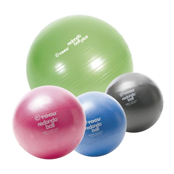 Verschiedene bunte Gymnastikbälle in Grün, Pink, Blau und Schwarz für Fitness und Therapie.