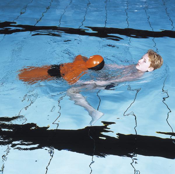 Junge lernt Schwimmen mit Rettungspuppe im Schwimmbecken, Schwimmunterricht Praxis.