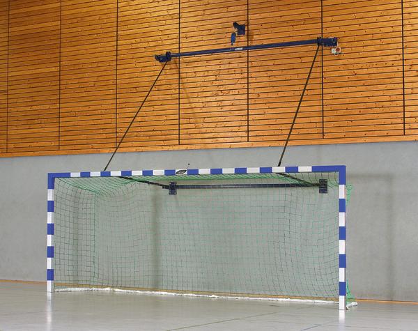 Handballtor mit blau-weißen Pfosten und grünem Netz in Sporthalle vor Holzwand.
