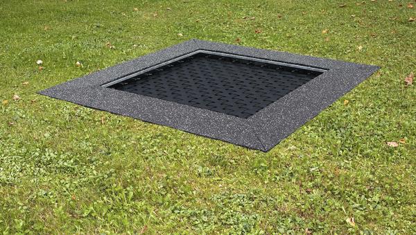 Trampolin bodengleich in Rasenfläche integriert mit schwarzem Sprungtuch und Umrandung.