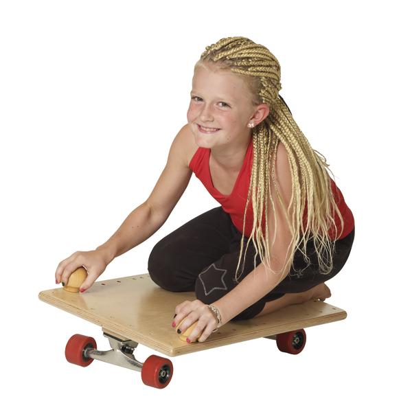 Mädchen mit geflochtenen Haaren fährt auf einem Holzroller mit roten Rollen, lächelnd.