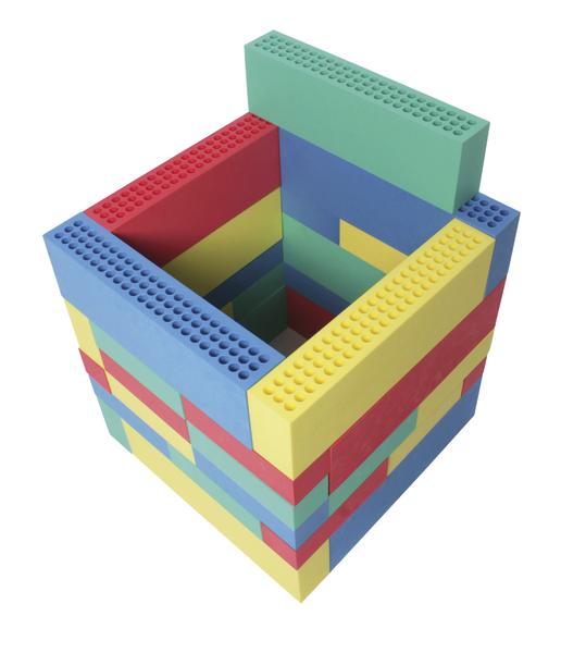 Bunter Turm aus großen Bauklötzen in Rot, Gelb, Blau und Grün auf weißem Hintergrund.