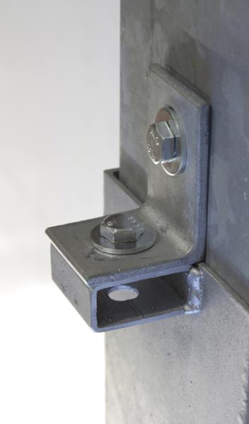 Metallwinkel mit zwei Schrauben an einer Betonwand befestigt, Nahaufnahme.