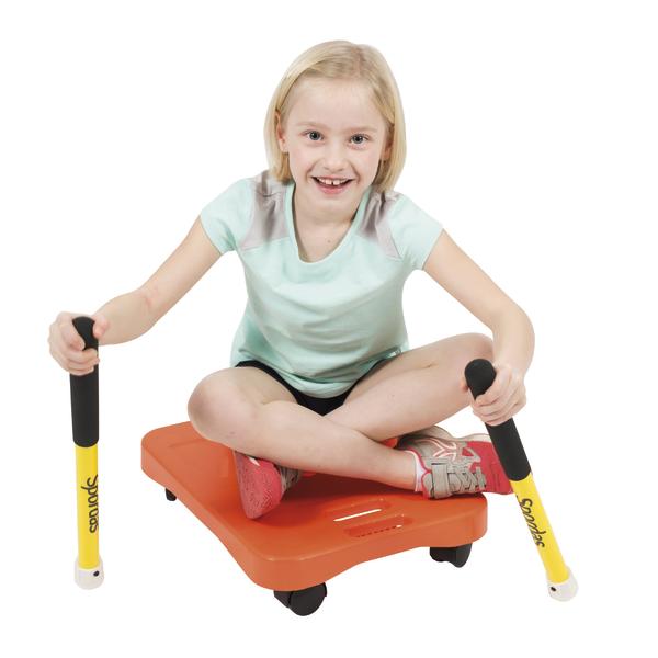 Mädchen sitzt auf orangefarbenem Rollbrett und hält gelbe Scooter-Stangen in den Händen.