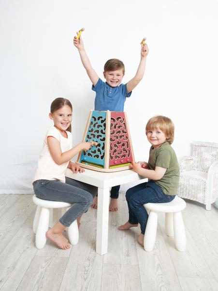 Drei Kinder spielen gemeinsam an einem Tisch mit einem bunten Labyrinth-Spielzeug.
