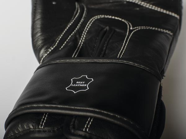 Schwarzer Boxhandschuh mit weißer Naht und "Best Leather" Logo, Nahaufnahme.