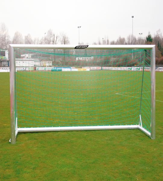 Fußballtor mit grünem Netz auf einem Rasenplatz bei bewölktem Himmel.