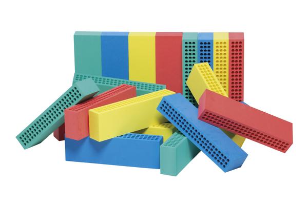 Bunte Kunststoffbausteine mit Löchern, gestapelt und verstreut auf weißem Hintergrund.