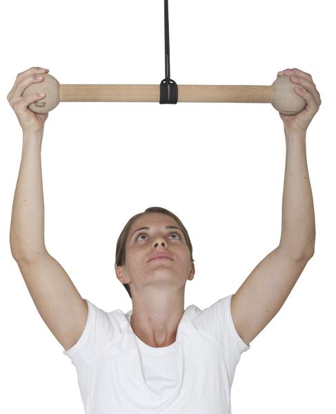 Frau trainiert mit Holzgriff an Hangelgerät für Oberkörperkraft und Koordination.