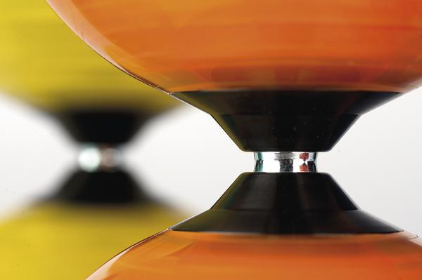 Nahaufnahme eines orangefarbenen Diabolo-Jongliergeräts auf weißem Hintergrund.