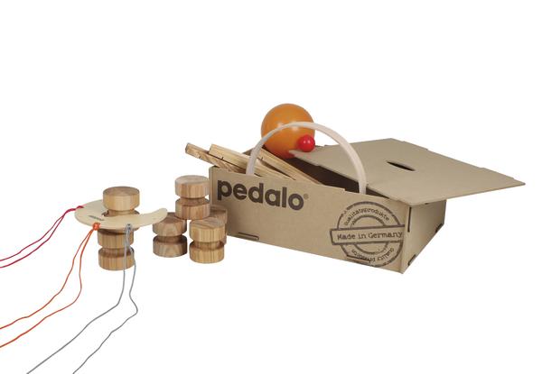 Pedalo Holzspielzeug mit Schnüren und orangem Ball in geöffneter Kartonverpackung, Made in Germany.