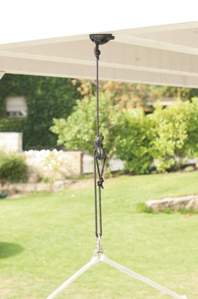 Hängemattenaufhängung mit Seil und Karabiner an einer Holzdecke im Garten.