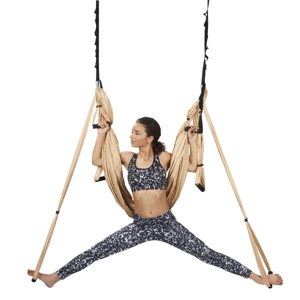Frau trainiert mit Yoga-Schaukel im gespreizten Spagat, Fitness und Dehnung.