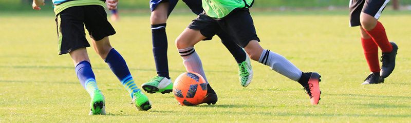 Kinder beim Fußballspielen auf dem Rasen – Bewegung, Teamgeist und Spaß am Sport.