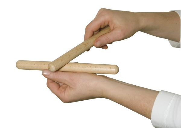 Zwei Hände halten und schlagen Holzklöppel für rhythmische Klänge.