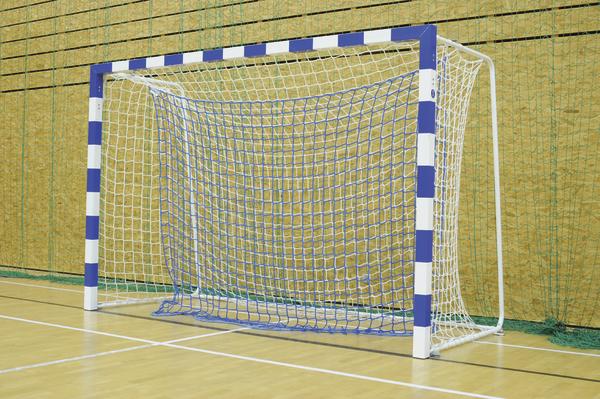 Handballtor mit blau-weißem Rahmen und Netz in einer Sporthalle auf Holzboden.
