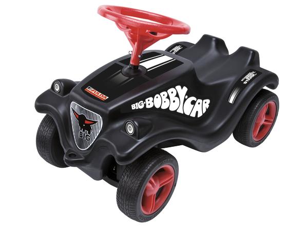Schwarzes Bobby-Car mit rotem Lenkrad und Reifen, Kinderfahrzeug zum Rutschen.