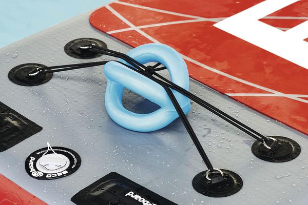 Rotes und graues Stand-Up-Paddleboard mit blauer Leash und schwarzen Bungee-Seilen.