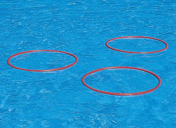 Drei rote Schwimmringe schwimmen auf klarem blauem Wasser.