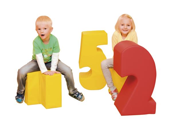 Kind Junge und Mädchen sitzen auf großen bunten Zahlen 1, 5 und 2 vor weißem Hintergrund.