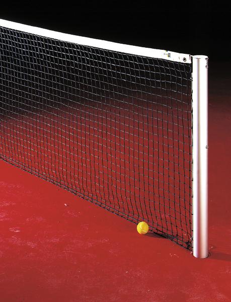 Tennisnetz auf rotem Platz mit gelbem Tennisball am Netzpfosten.