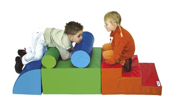 Kinder spielen auf bunten Schaumstoffbausteinen in verschiedenen Formen und Farben.