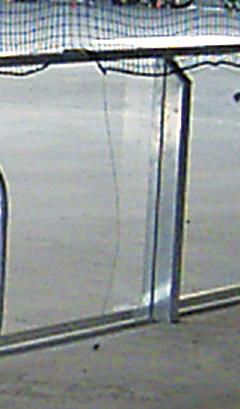 Metallgeländer mit Glasfüllung an einer Treppe oder Brüstung bei Tageslicht.