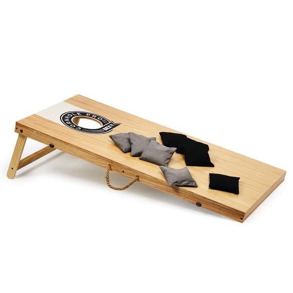 Cornhole-Spielbrett aus Holz mit klappbaren Beinen und Lochziel, inklusive mehreren Wurfsäckchen in zwei Farben für das Spiel.