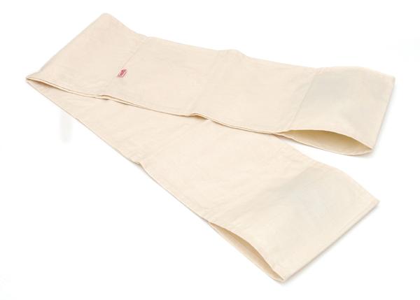 Beiges Pilates Band, flach liegend auf weißem Hintergrund, schlichtes Design.